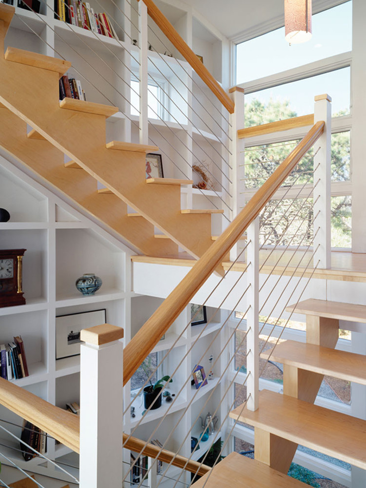Photo of an industrial wood u-shaped staircase in San Francisco with open risers and cable railing.