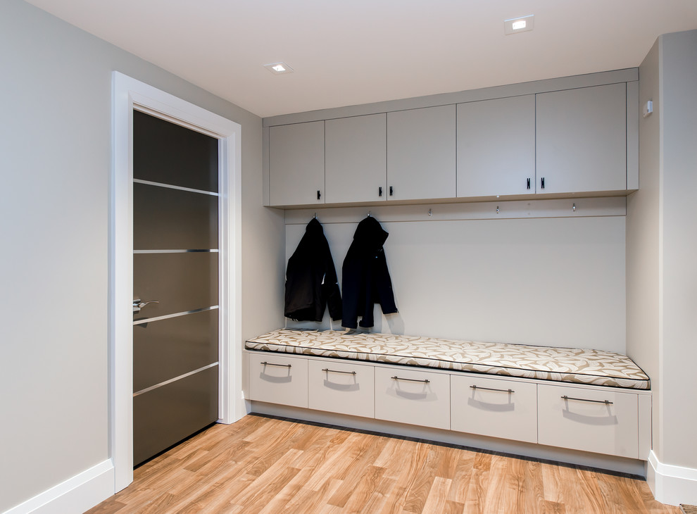 Mid-sized contemporary mudroom in Calgary with grey walls and light hardwood floors.