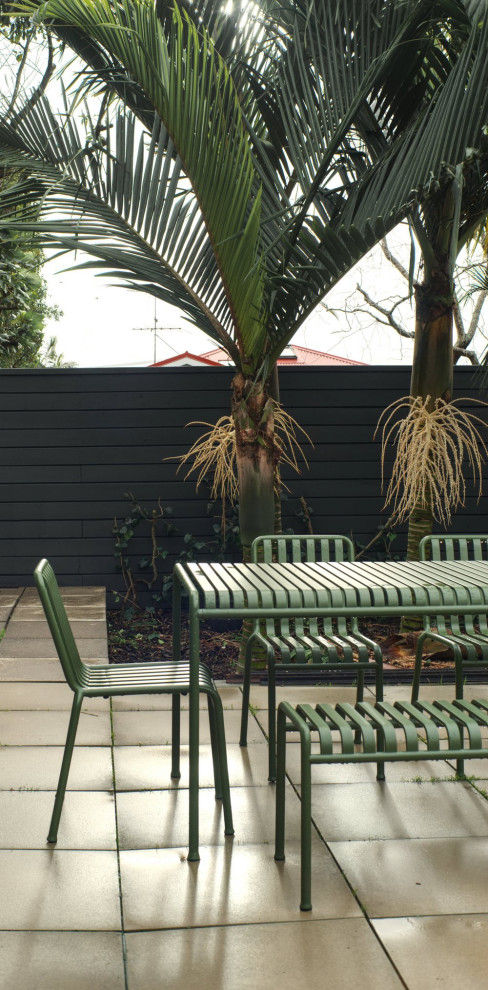 Idée de décoration pour une terrasse arrière design de taille moyenne avec des pavés en béton et aucune couverture.