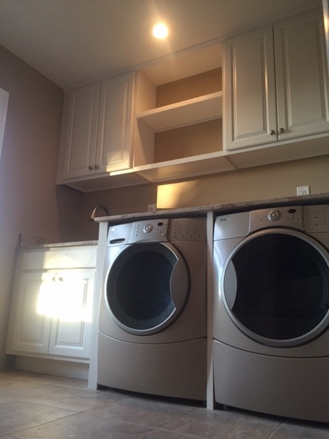 Utility room - mid-sized transitional u-shaped ceramic tile utility room idea in Phoenix with an undermount sink, raised-panel cabinets, white cabinets, granite countertops, beige walls and a side-by-side washer/dryer