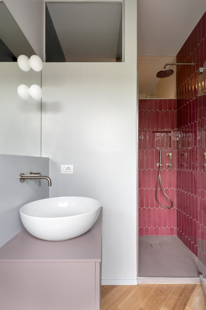 Идея дизайна: ванная комната среднего размера в современном стиле с фасадами с выступающей филенкой, фиолетовыми фасадами, душем в нише, инсталляцией, розовой плиткой, керамогранитной плиткой, серыми стенами, паркетным полом среднего тона, душевой кабиной, настольной раковиной, столешницей из дерева, душем с распашными дверями, фиолетовой столешницей, тумбой под одну раковину и подвесной тумбой