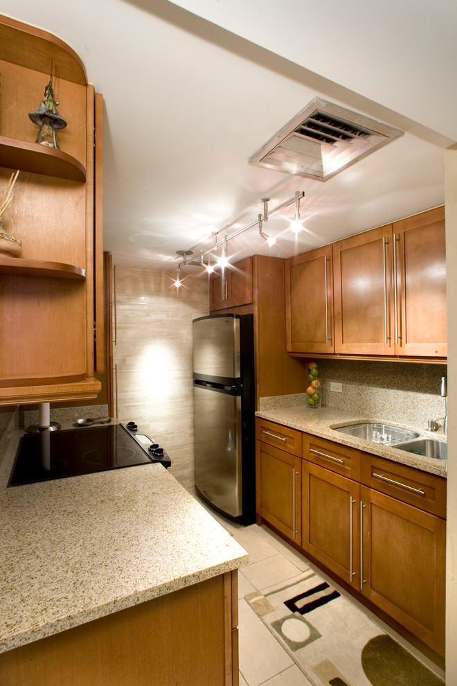Small transitional galley ceramic tile enclosed kitchen photo with a double-bowl sink, shaker cabinets, medium tone wood cabinets, granite countertops, beige backsplash, stone slab backsplash, stainless steel appliances and no island