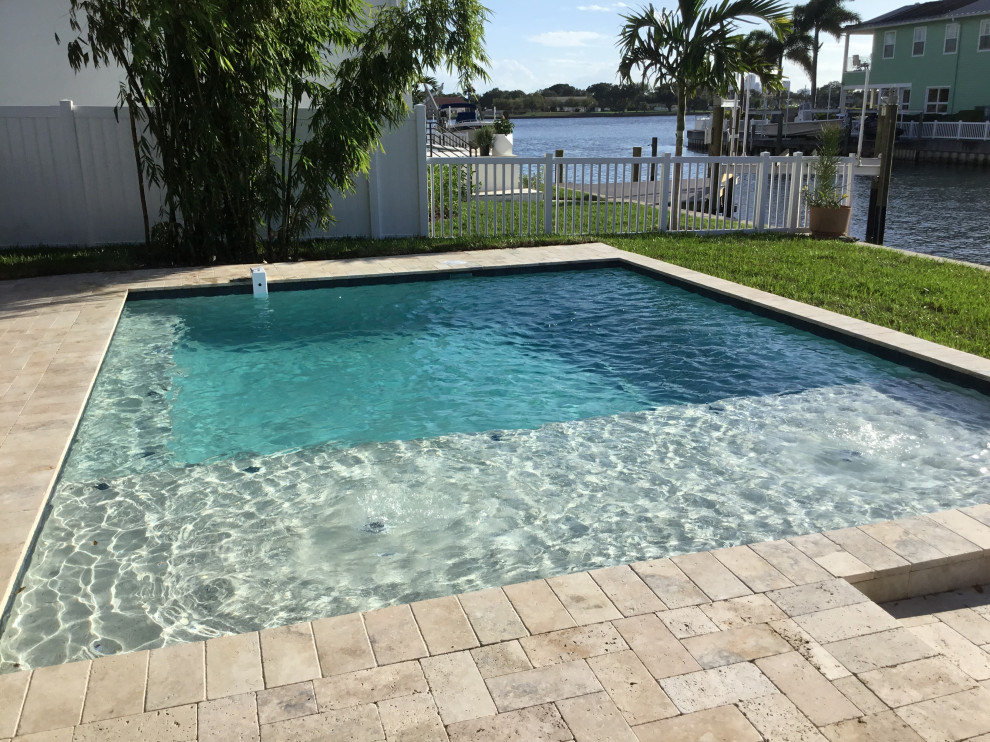 Example of a mid-sized minimalist backyard stone and rectangular natural pool design in Tampa