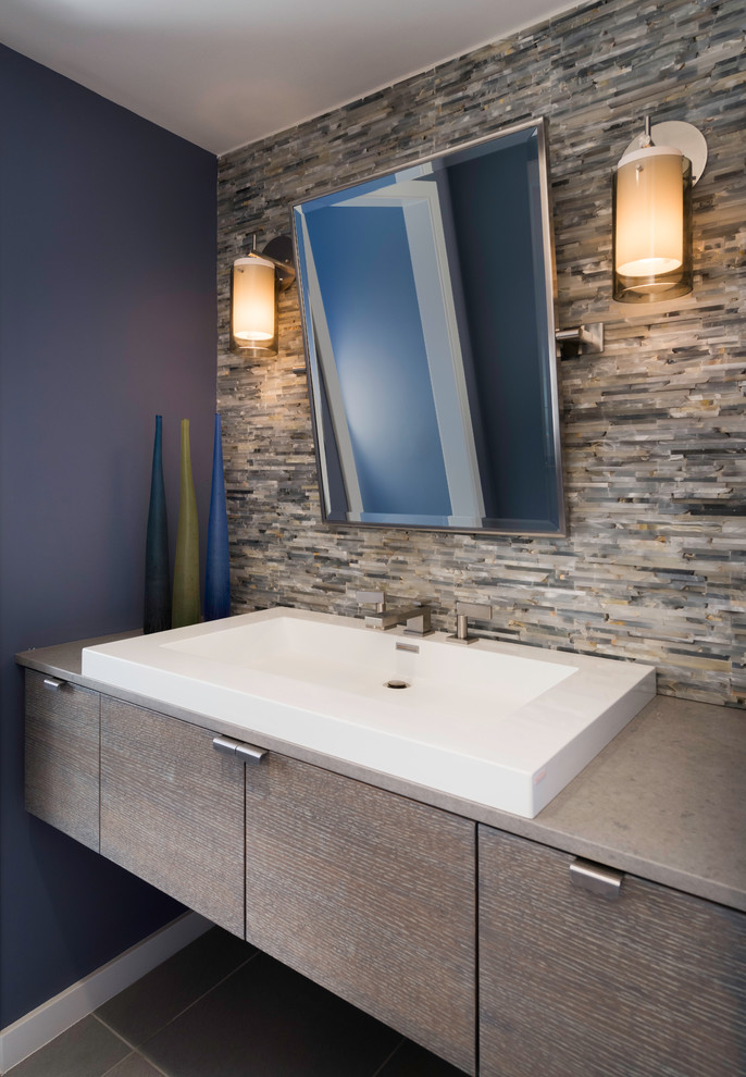 This is an example of a small midcentury powder room in Boston with a vessel sink, flat-panel cabinets, medium wood cabinets, engineered quartz benchtops, gray tile, purple walls and ceramic floors.