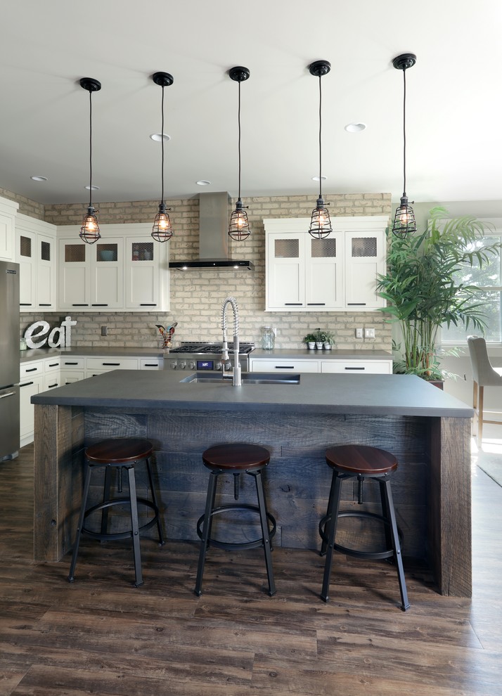 Inspiration for an industrial kitchen in Grand Rapids with an undermount sink, recessed-panel cabinets, white cabinets, concrete benchtops, stainless steel appliances, dark hardwood floors and with island.