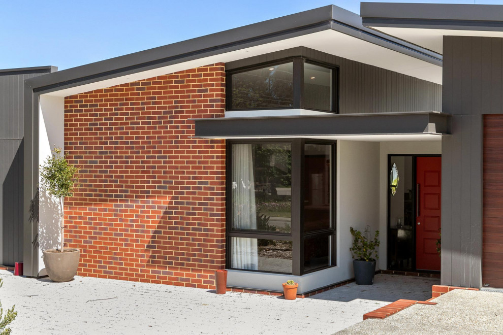 Inspiration for a mid-sized industrial one-storey black house exterior in Perth with a shed roof, a metal roof and a black roof.