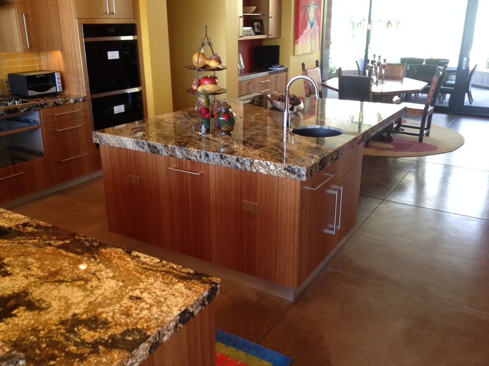 Inspiration for a mid-sized transitional concrete floor eat-in kitchen remodel in Phoenix with an undermount sink, flat-panel cabinets, medium tone wood cabinets, granite countertops, yellow backsplash and an island