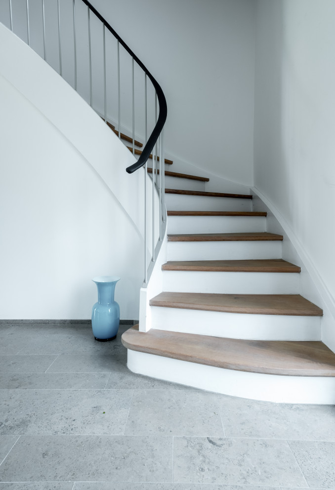 Inspiration for a contemporary wood l-shaped staircase in Munich with wood risers and metal railing.