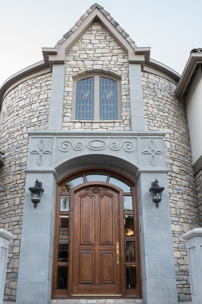 This is an example of a medium sized victorian front door in Los Angeles with grey walls, limestone flooring, a single front door and a dark wood front door.