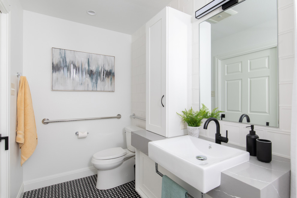 Foto på ett mellanstort vintage grå en-suite badrum, med vita skåp, ett hörnbadkar, en kantlös dusch, vit kakel, vita väggar, ett nedsänkt handfat, bänkskiva i kvarts, flerfärgat golv och dusch med duschdraperi