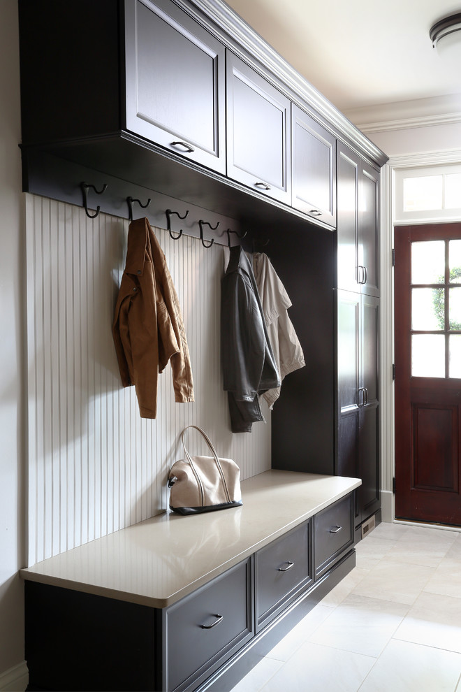 Entryway - mid-sized transitional galley porcelain tile entryway idea in Chicago with recessed-panel cabinets, dark wood cabinets and quartz countertops