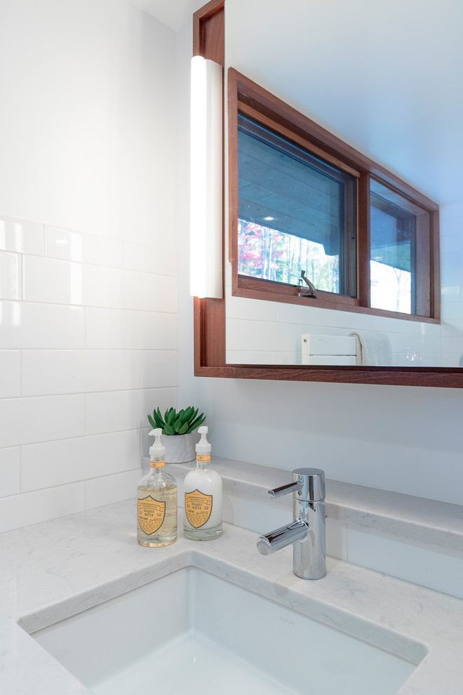 Photo of a small modern master bathroom in Boston with open cabinets, medium wood cabinets, an open shower, a wall-mount toilet, white tile, ceramic tile, white walls, marble floors, an undermount sink and engineered quartz benchtops.
