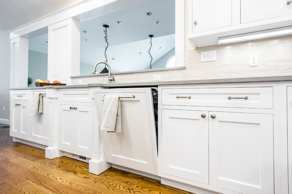 This is an example of a mid-sized traditional u-shaped separate kitchen in Boston with an undermount sink, shaker cabinets, stainless steel appliances, dark hardwood floors, with island, white cabinets, granite benchtops, beige splashback and porcelain splashback.