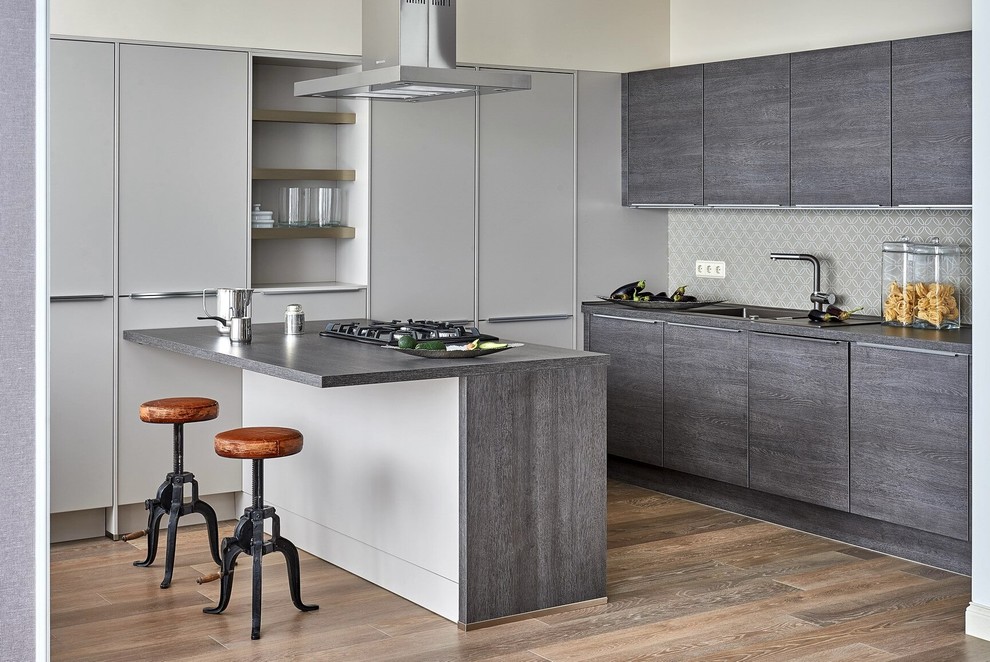 Design ideas for a mid-sized contemporary u-shaped eat-in kitchen in Moscow with a single-bowl sink, flat-panel cabinets, grey cabinets, laminate benchtops, grey splashback, porcelain splashback, medium hardwood floors, a peninsula and black appliances.