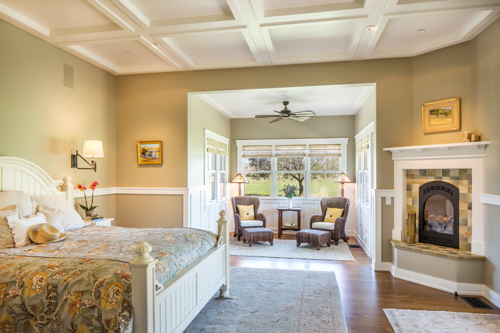 Inspiration for a large arts and crafts master bedroom in Santa Barbara with medium hardwood floors, a corner fireplace, beige walls and a tile fireplace surround.