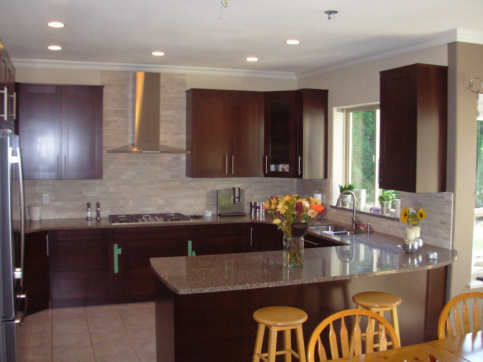 Example of a mid-sized transitional u-shaped beige floor kitchen design in Vancouver with a double-bowl sink, shaker cabinets, dark wood cabinets, quartz countertops, beige backsplash, porcelain backsplash, stainless steel appliances and a peninsula