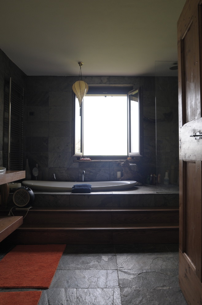 Idee per una stanza da bagno padronale country di medie dimensioni con nessun'anta, ante con finitura invecchiata, vasca da incasso, doccia a filo pavimento, WC sospeso, lastra di pietra e pavimento in ardesia