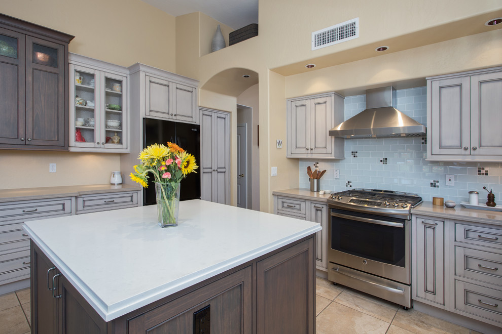 Example of a large transitional l-shaped ceramic tile open concept kitchen design in Phoenix with an undermount sink, beaded inset cabinets, gray cabinets, quartz countertops, white backsplash, glass tile backsplash, black appliances and an island