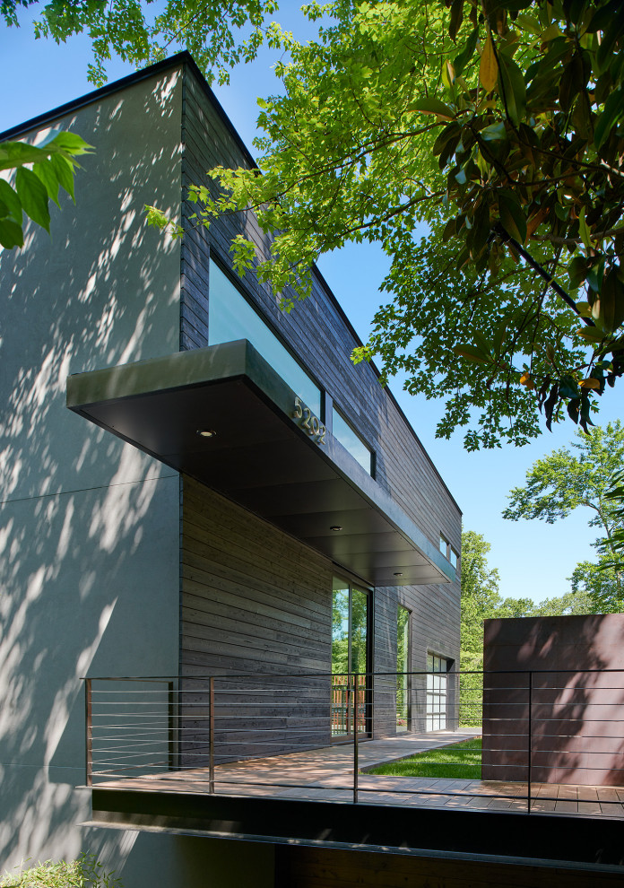 Design ideas for a mid-sized modern three-storey black house exterior in Other with wood siding.