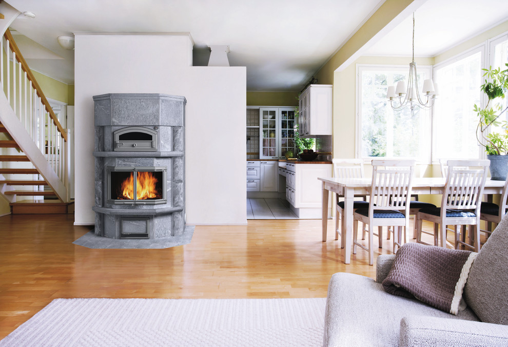 This is an example of a large scandinavian dining room in Gloucestershire with a wood stove.