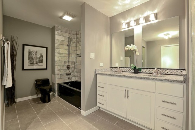 Inspiration for a large transitional master bathroom in Chicago with white cabinets, an alcove tub, a shower/bathtub combo, a one-piece toilet, gray tile, porcelain tile, grey walls, porcelain floors, a drop-in sink, granite benchtops, shaker cabinets, grey floor and an open shower.