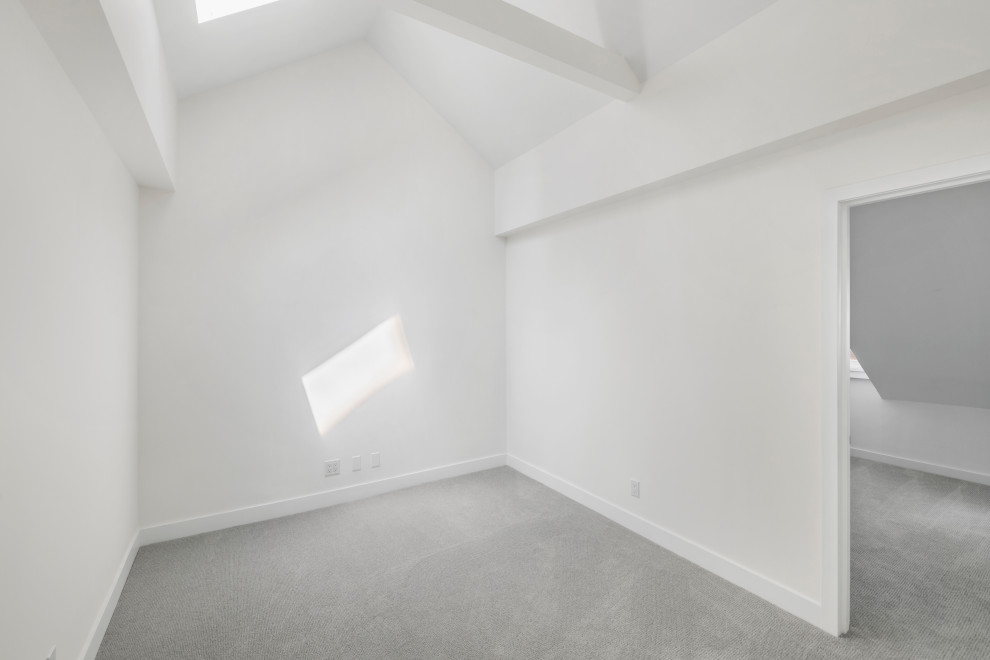 Klassisk inredning av ett mellanstort sovloft, med vita väggar, heltäckningsmatta och grått golv