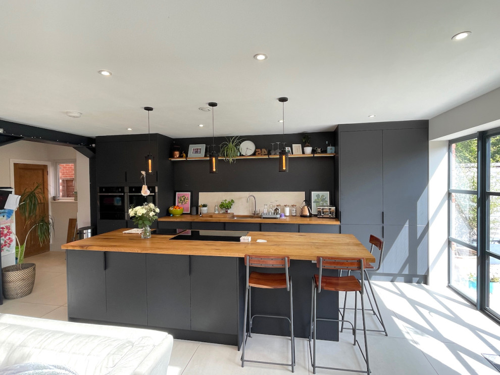 Offene Moderne Küche in grau-weiß in U-Form mit grauen Schränken, Arbeitsplatte aus Holz, Keramikboden, Kücheninsel, weißem Boden und brauner Arbeitsplatte in Berkshire
