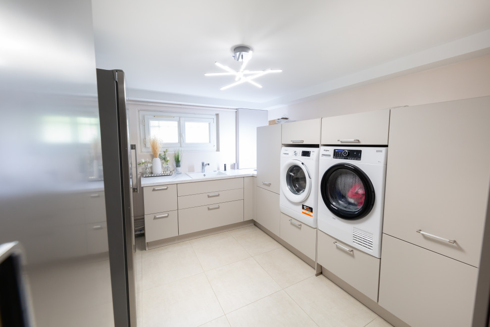 Immagine di una lavanderia classica di medie dimensioni con lavello a vasca singola, pareti beige, lavatrice e asciugatrice affiancate, pavimento beige e top bianco