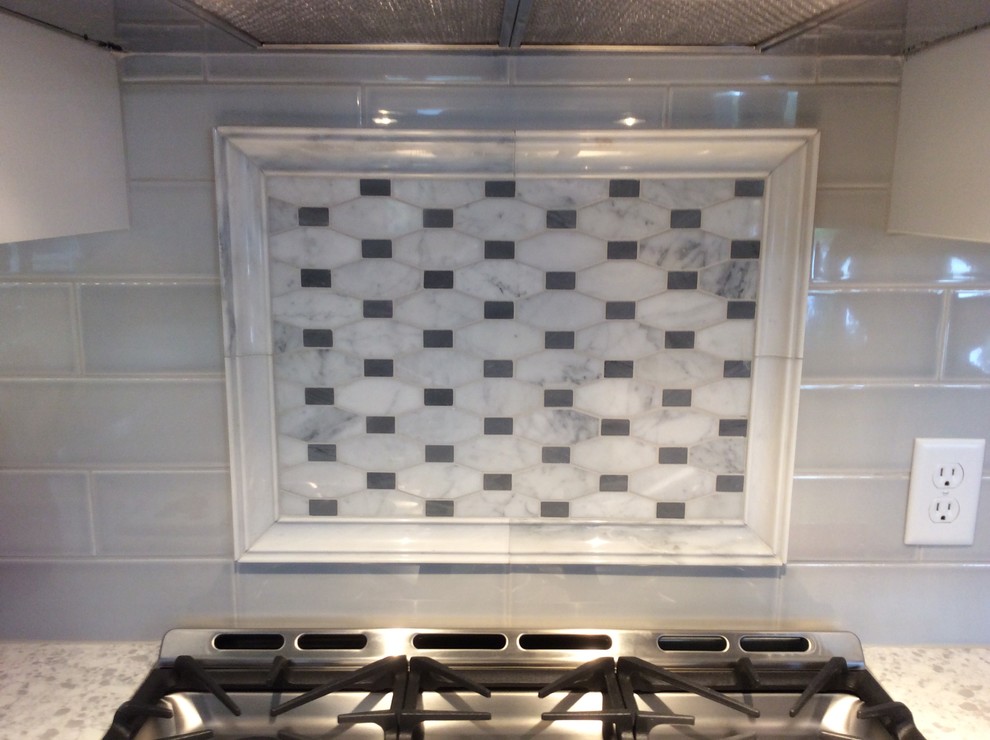 Mid-sized transitional l-shaped dark wood floor enclosed kitchen photo with an undermount sink, raised-panel cabinets, white cabinets, quartz countertops, gray backsplash, mosaic tile backsplash, stainless steel appliances and an island