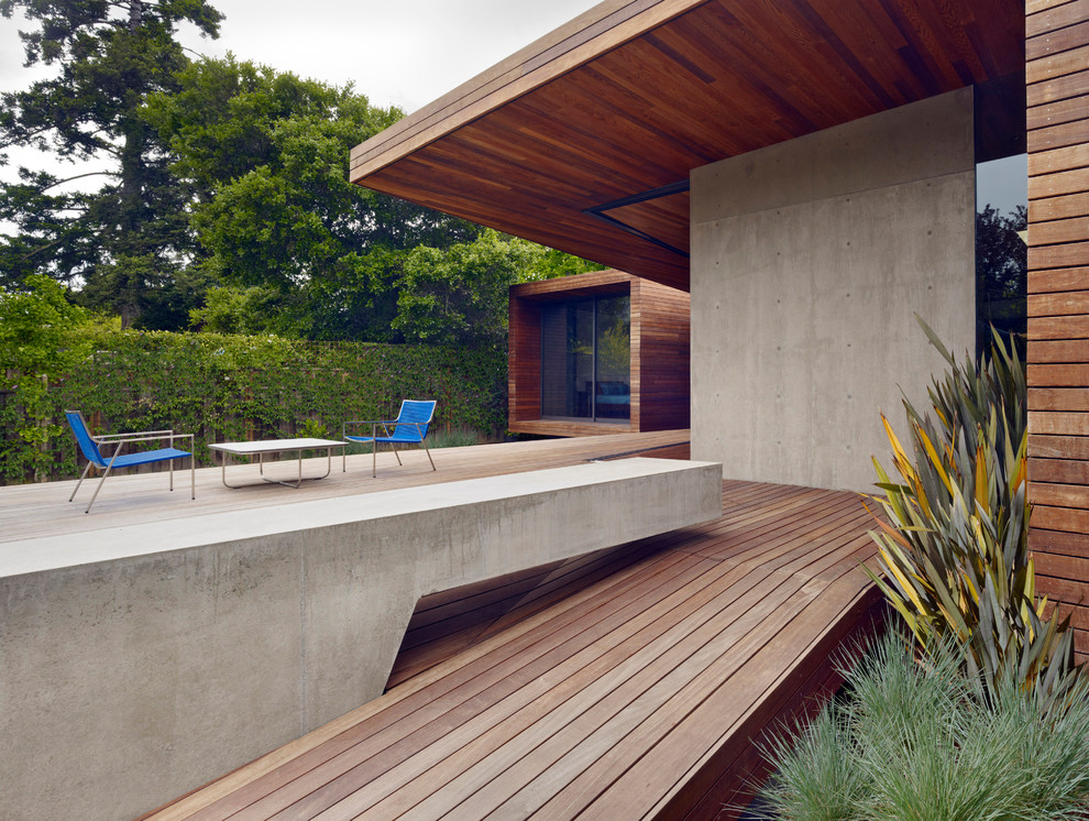 Mid-sized modern backyard deck in San Francisco with a roof extension.