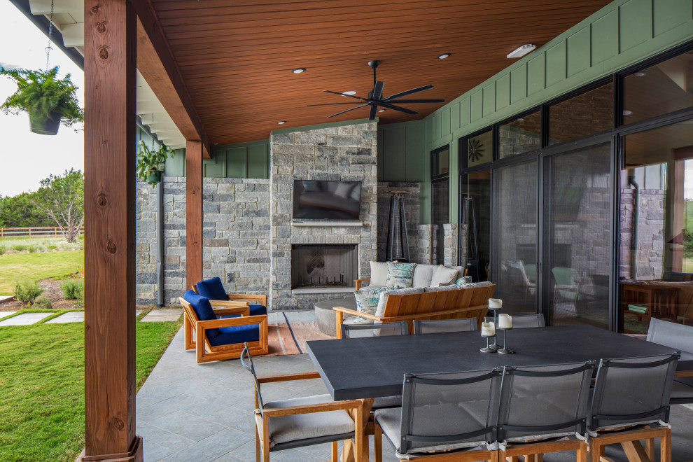 Country patio in Austin with with fireplace and a roof extension.