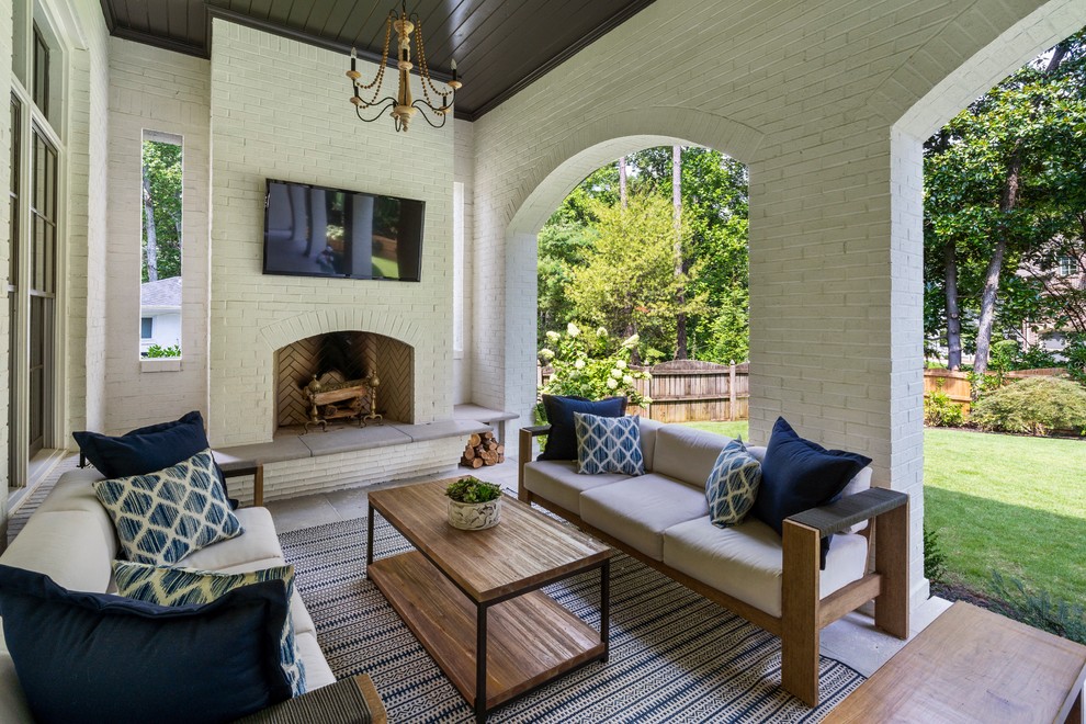 Photo of a transitional backyard patio in Atlanta with with fireplace and a roof extension.