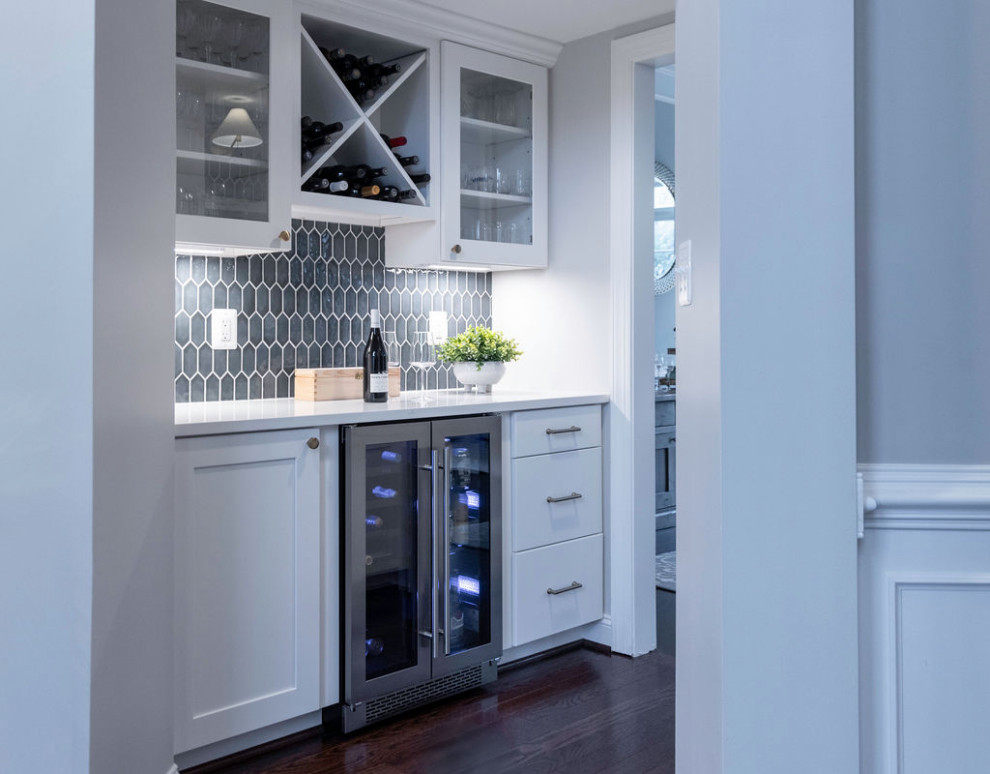 Inspiration for a large transitional u-shaped medium tone wood floor kitchen remodel in DC Metro with a single-bowl sink, flat-panel cabinets, quartz countertops, white backsplash, porcelain backsplash, stainless steel appliances, an island and white countertops