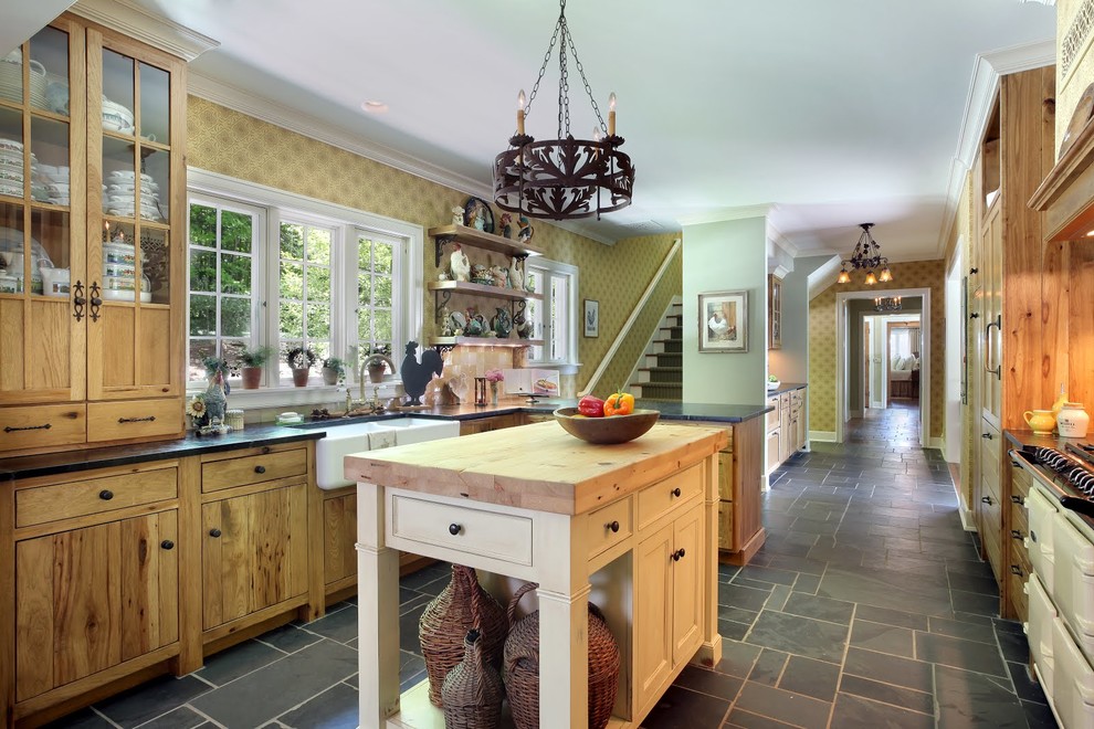 Photo of a country kitchen in Grand Rapids with a farmhouse sink, flat-panel cabinets, green cabinets, recycled glass benchtops, metallic splashback, terra-cotta splashback, coloured appliances, slate floors and with island.