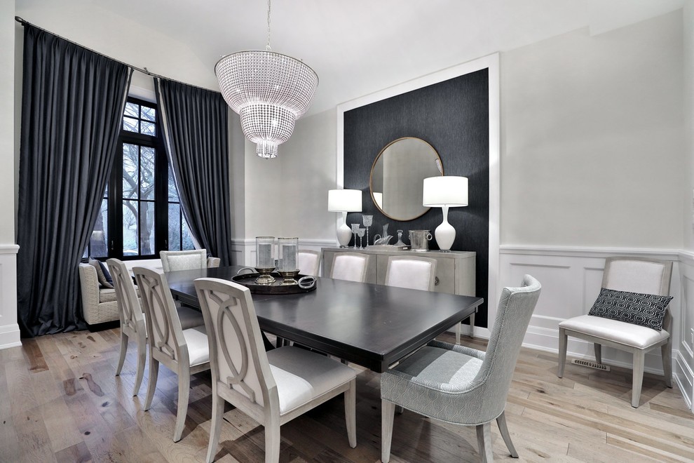 This is an example of a mid-sized transitional separate dining room with grey walls and light hardwood floors.
