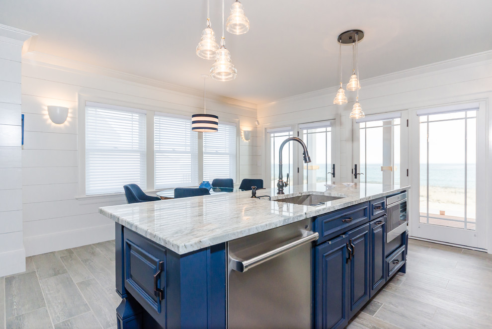Inspiration for a beach style single-wall eat-in kitchen in Boston with raised-panel cabinets, blue cabinets, granite benchtops, white splashback, stainless steel appliances and with island.