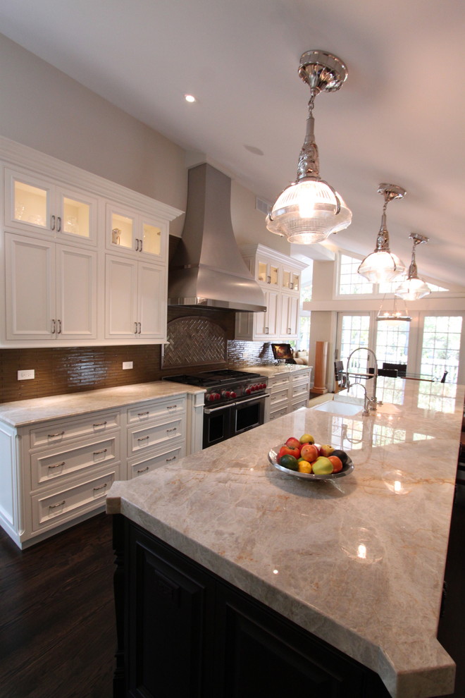 This is an example of a large traditional l-shaped open plan kitchen in Chicago with beaded inset cabinets, white cabinets, with island, a farmhouse sink, marble benchtops, stainless steel appliances, dark hardwood floors and brown floor.