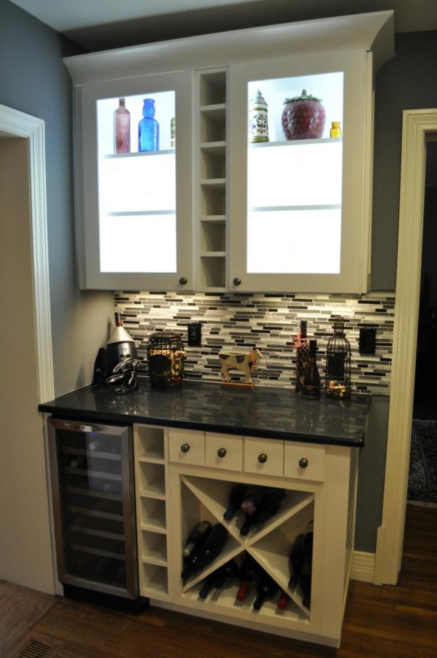 Eat-in kitchen - transitional dark wood floor eat-in kitchen idea with shaker cabinets, white cabinets, granite countertops, multicolored backsplash, glass tile backsplash and stainless steel appliances
