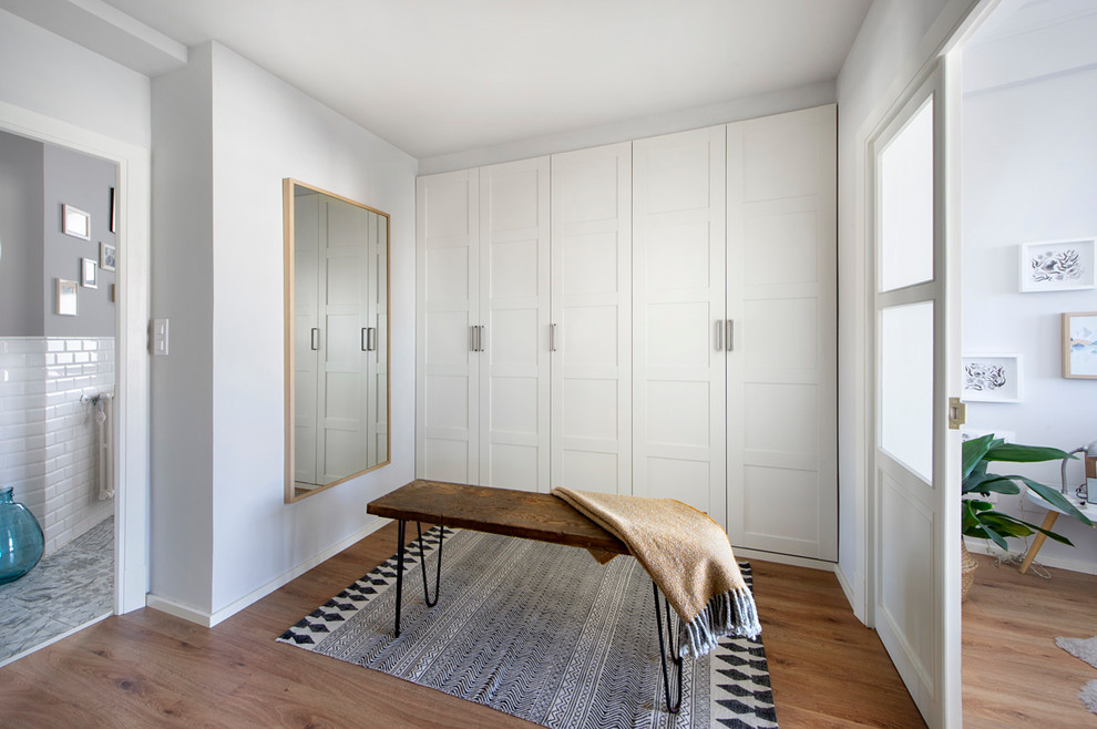 Photo of a small contemporary gender-neutral walk-in wardrobe in Barcelona with white cabinets.
