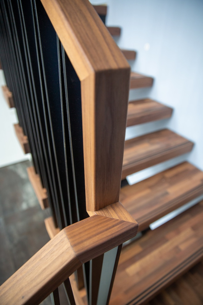 Example of a mid-sized trendy wooden floating open and metal railing staircase design in Auckland