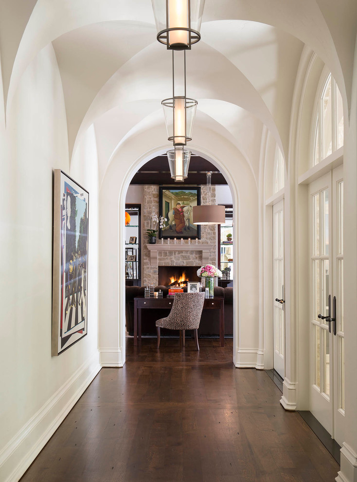 This is an example of a transitional hallway in Dallas with white walls and dark hardwood floors.