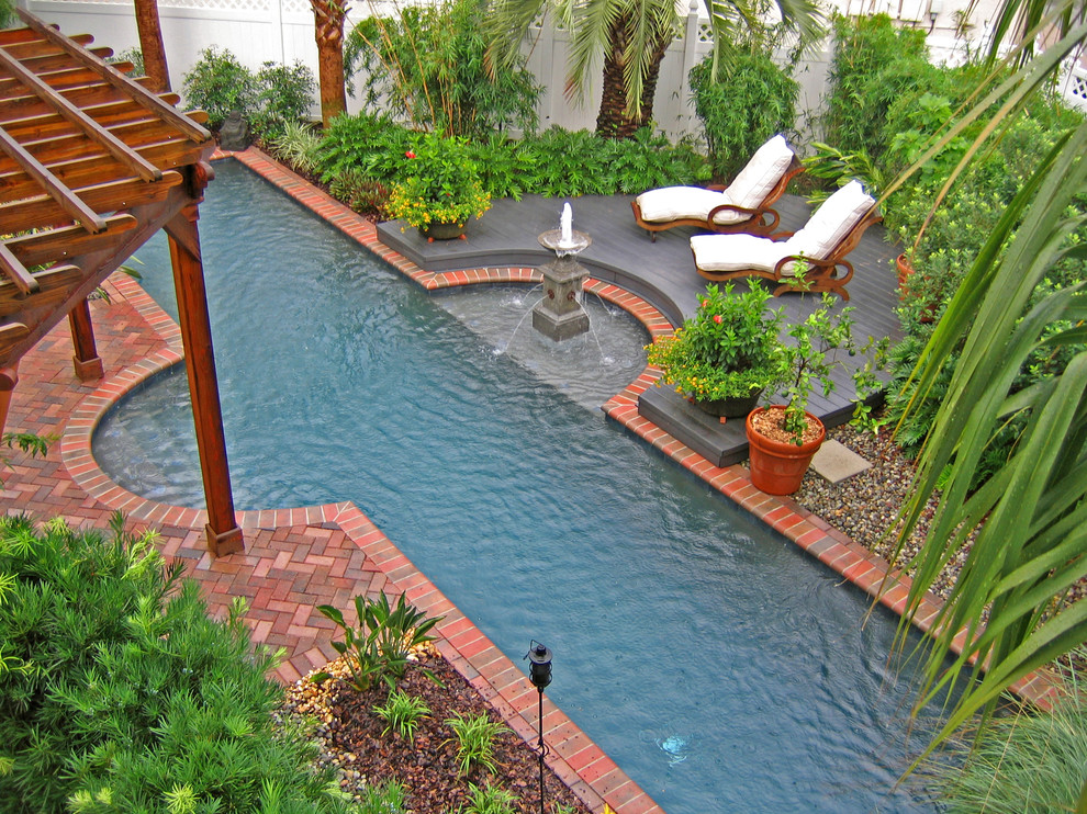 Inspiration for a tropical pool in Orlando with brick pavers.