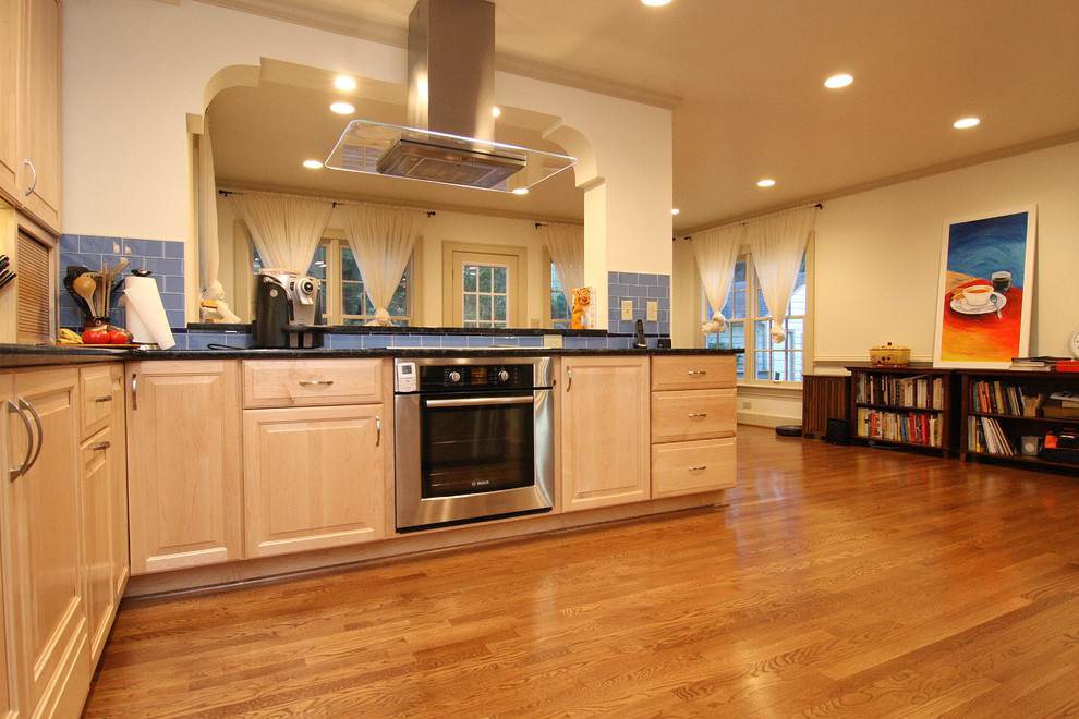 Inspiration for a huge transitional l-shaped medium tone wood floor open concept kitchen remodel with an undermount sink, raised-panel cabinets, light wood cabinets, granite countertops, blue backsplash, glass tile backsplash and stainless steel appliances
