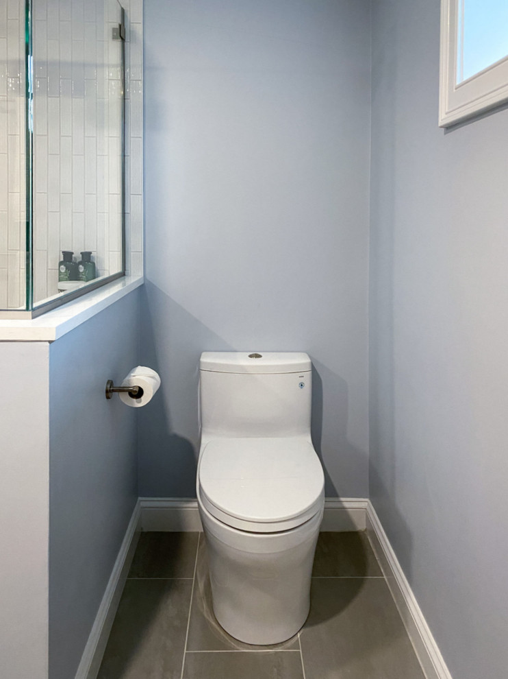 Transitional white tile and ceramic tile porcelain tile, gray floor and single-sink corner shower photo in Boston with shaker cabinets, gray cabinets, a one-piece toilet, gray walls, an undermount sink, quartz countertops, a hinged shower door, white countertops and a built-in vanity