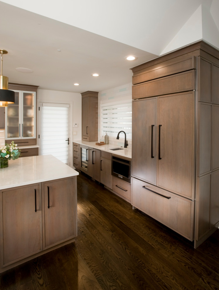 This is an example of a large transitional u-shaped eat-in kitchen in Wichita with an undermount sink, flat-panel cabinets, grey cabinets, quartz benchtops, white splashback, ceramic splashback, stainless steel appliances, dark hardwood floors, with island, brown floor and white benchtop.