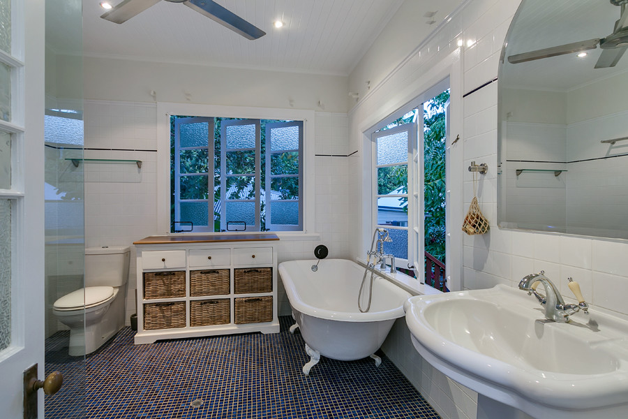 This is an example of a mid-sized master bathroom in Cairns with a claw-foot tub, a double shower, white tile, ceramic tile, white walls, ceramic floors, a drop-in sink, blue floor and a hinged shower door.