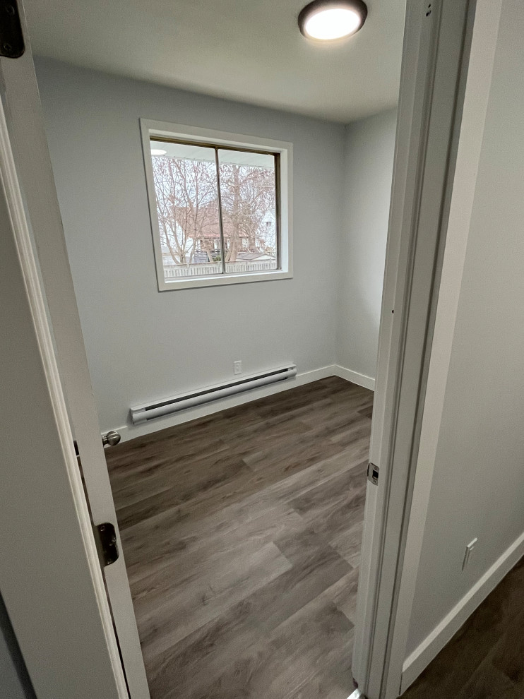 Exemple d'une chambre d'amis moderne de taille moyenne avec un mur blanc, un sol en vinyl et un sol gris.