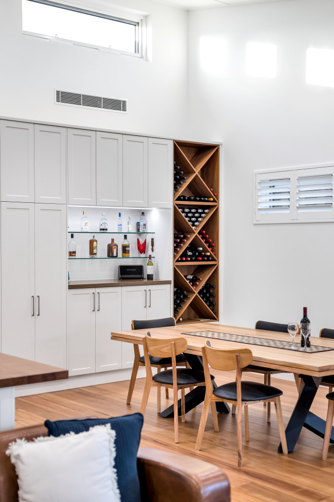 Photo of a contemporary open plan dining in Adelaide with white walls, medium hardwood floors and brown floor.