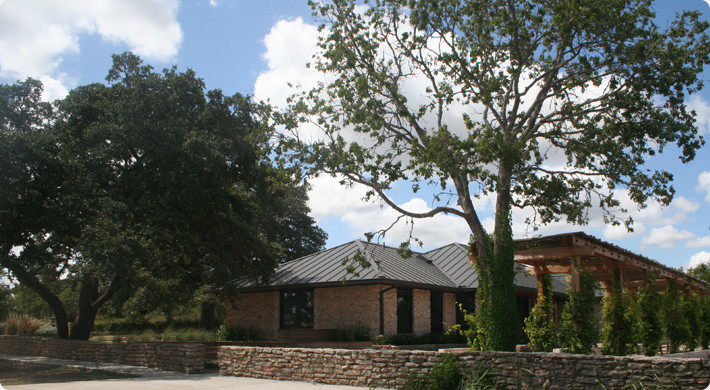 This is an example of a mid-sized country one-storey beige exterior in Austin with stone veneer and a hip roof.