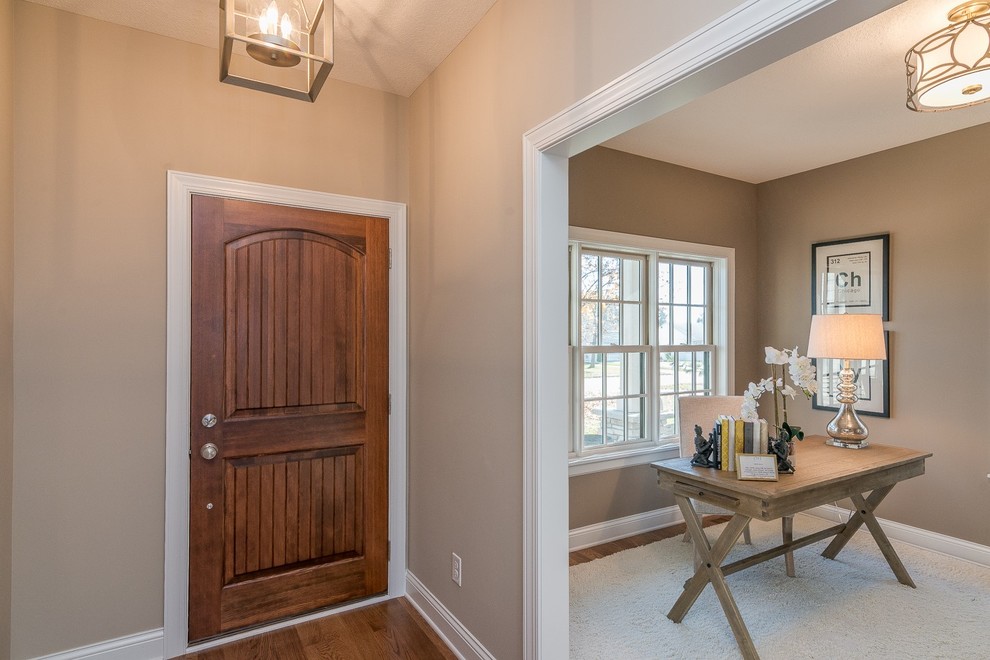 Inspiration for a small transitional medium tone wood floor and brown floor front door remodel in Minneapolis with gray walls and a medium wood front door